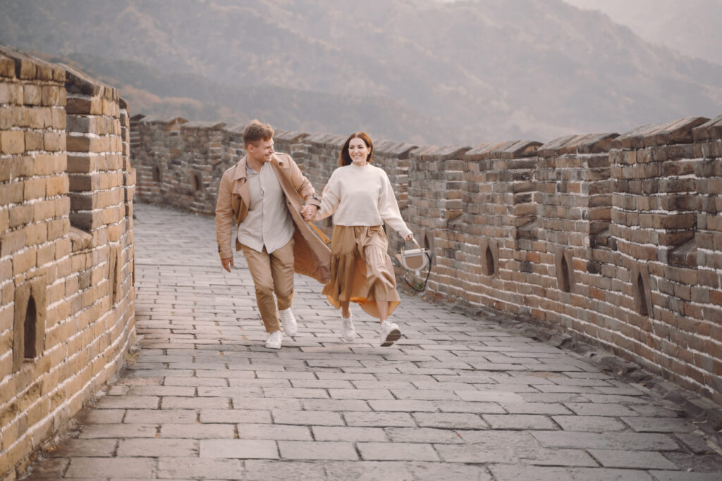 young couple running twirling great wall china scaled e1681883571851